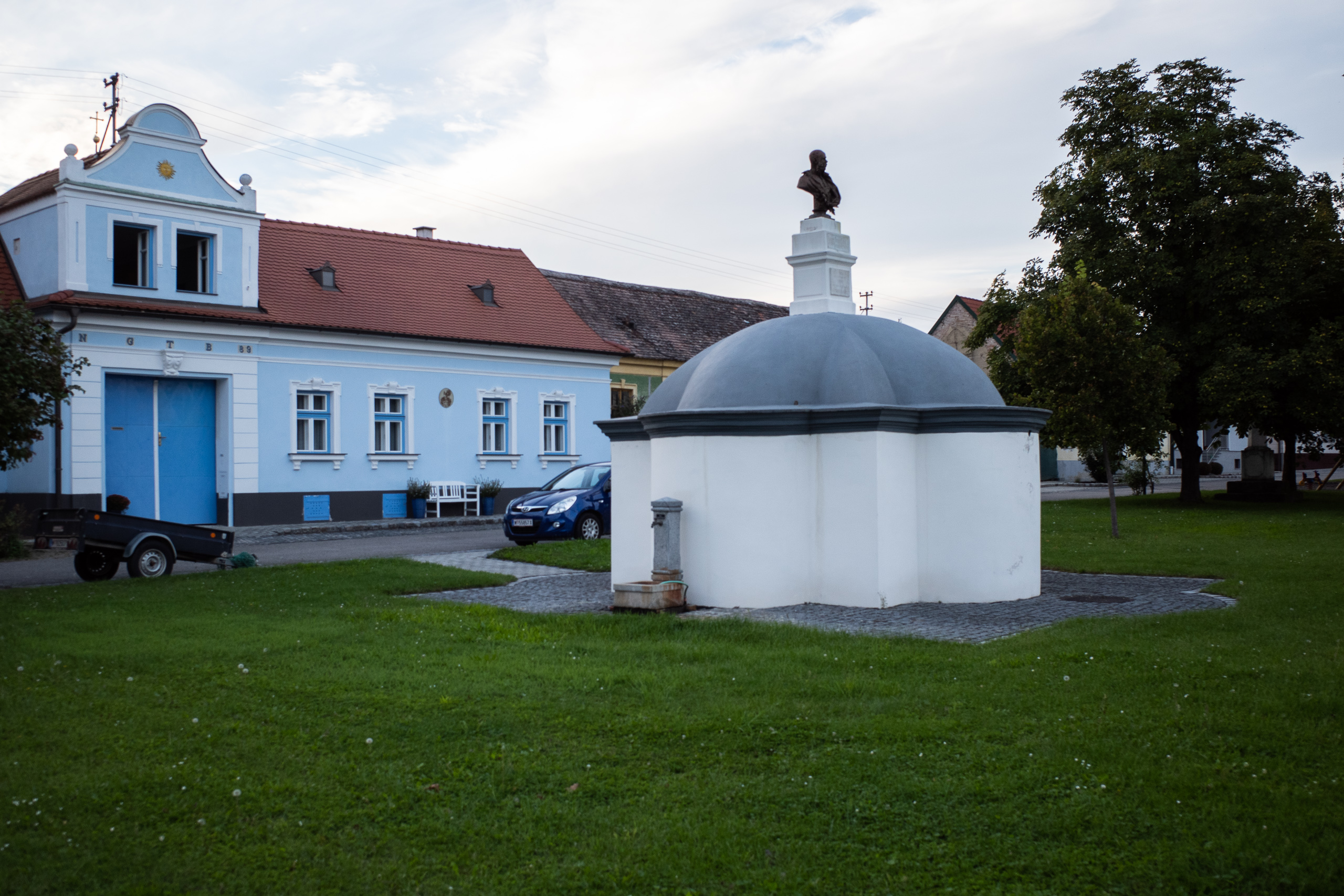 Am Anger: blaues Barockhaus und der gedeckte Brunnen mit Büste